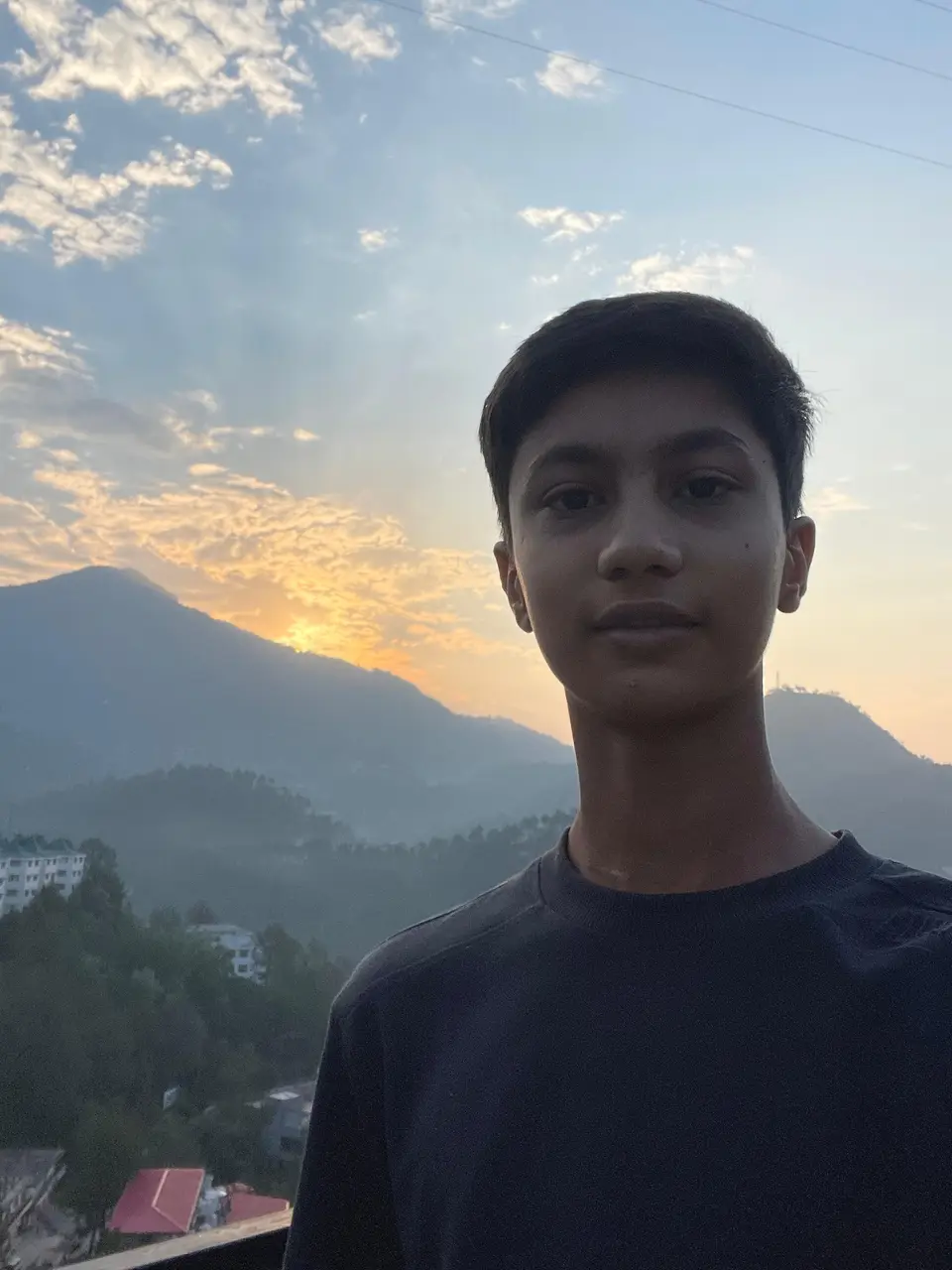 Aaradhy at sunset, mountains and a low sun behind him